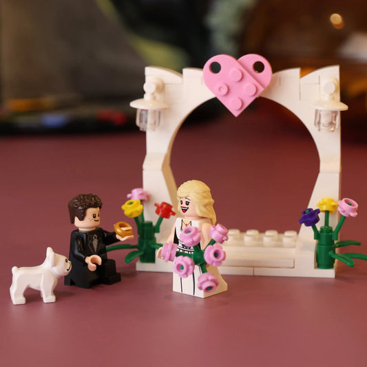 LEGO figures of a couple with a dog in front of a heart-shaped arch on a red background